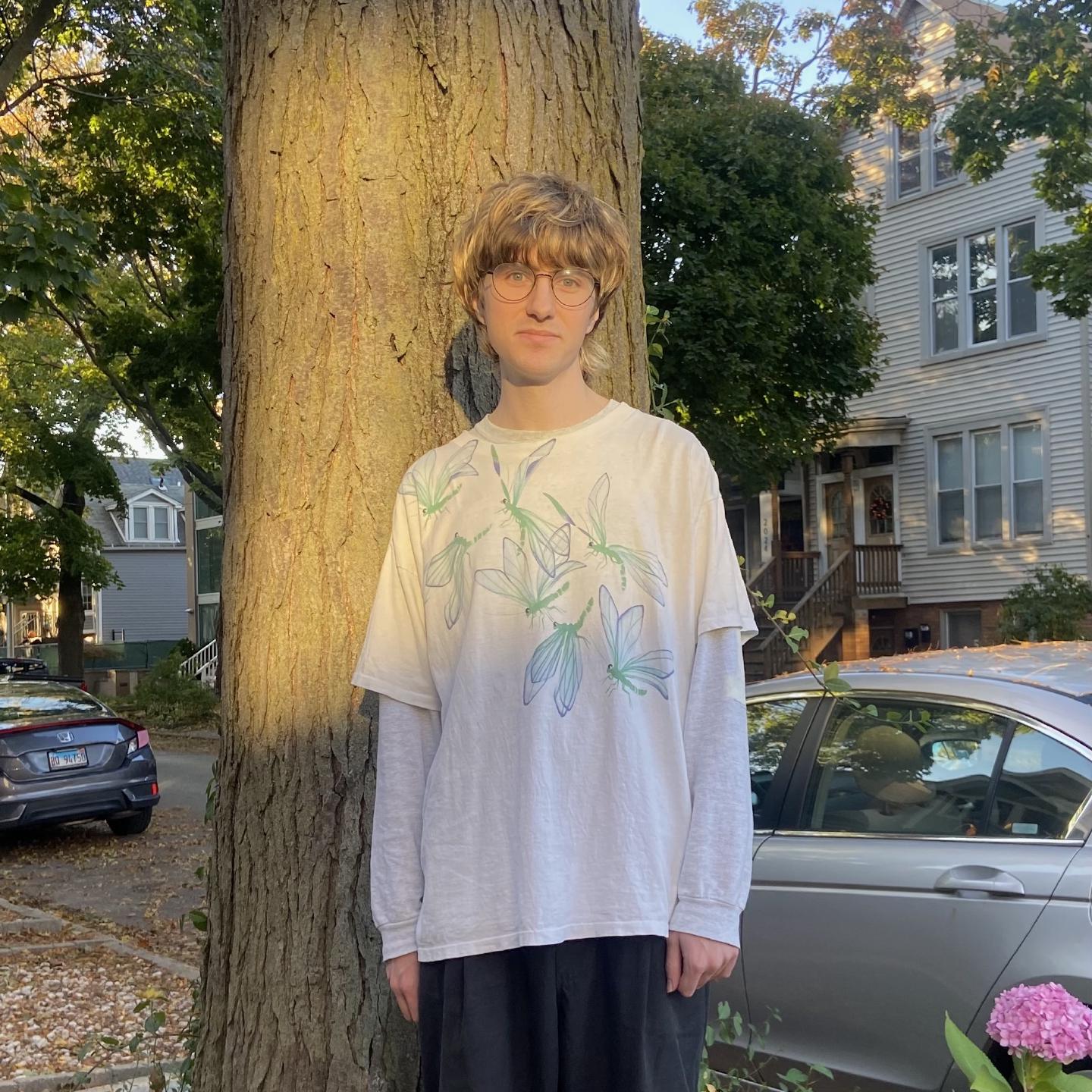 A photo of and standing in front of a tree in the sun